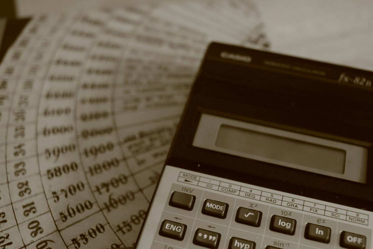 A calculator resting on printed financial ledger sheets