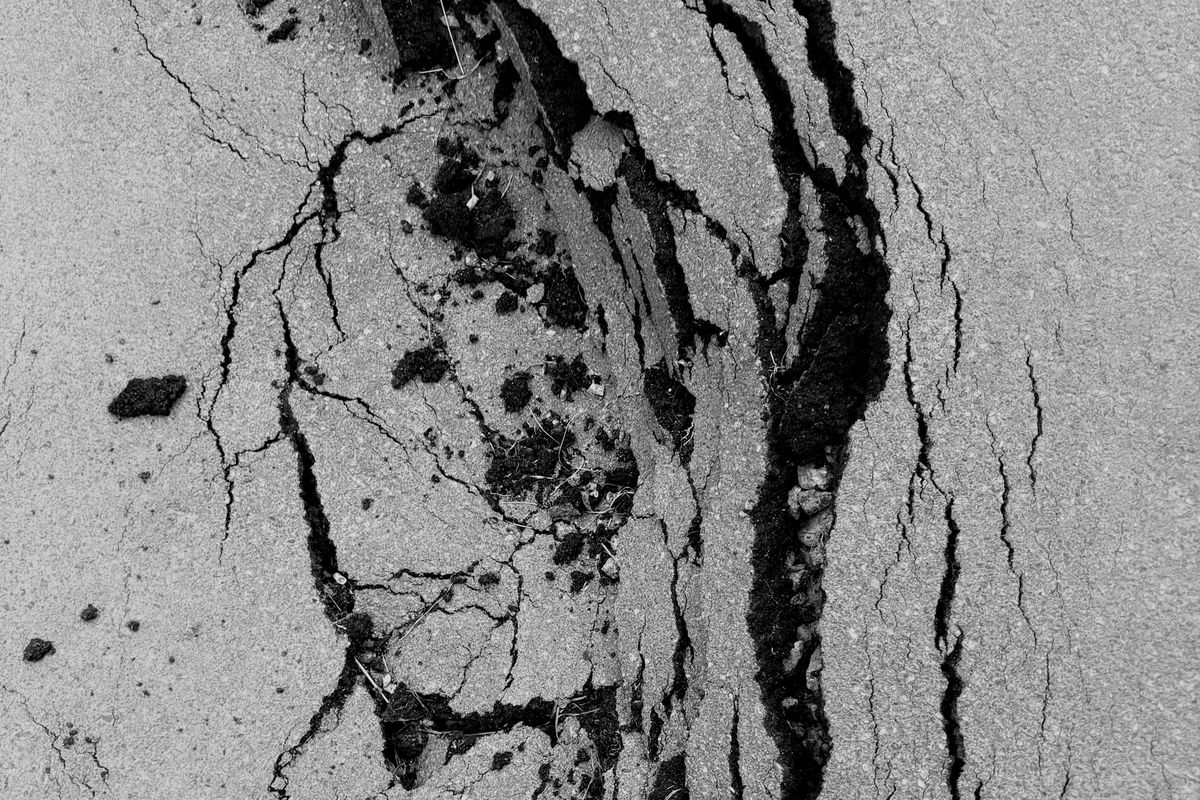 Cracked and broken asphalt, in black and white