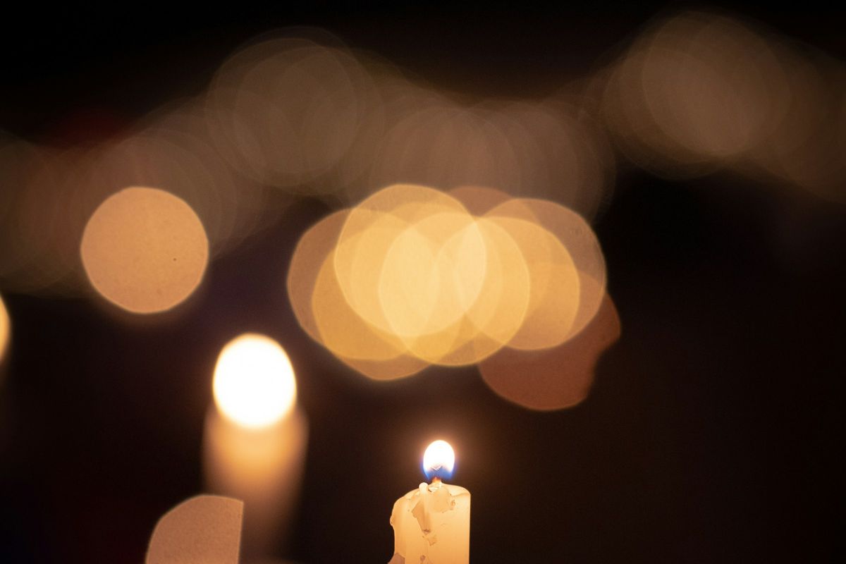 A lit candle against a dark background
