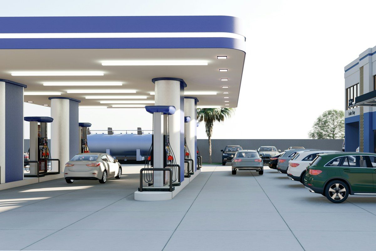 A green car is parked at a gas station