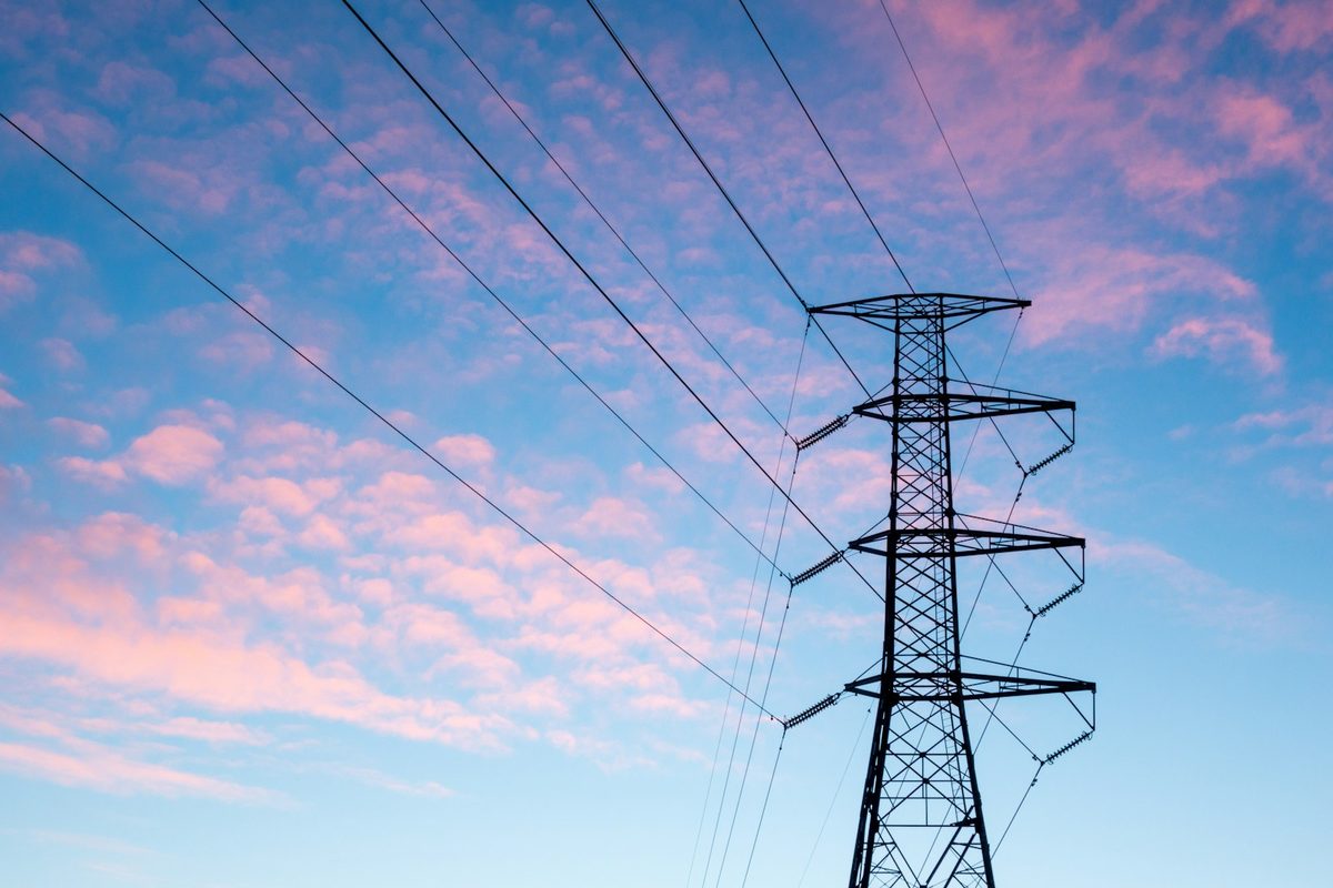 An electricity pylon under orange clouds
