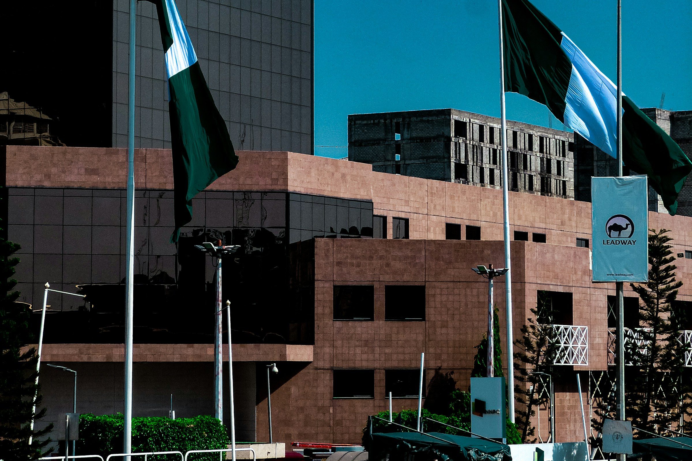 Nigerian flags flying before a government complex in Abuja