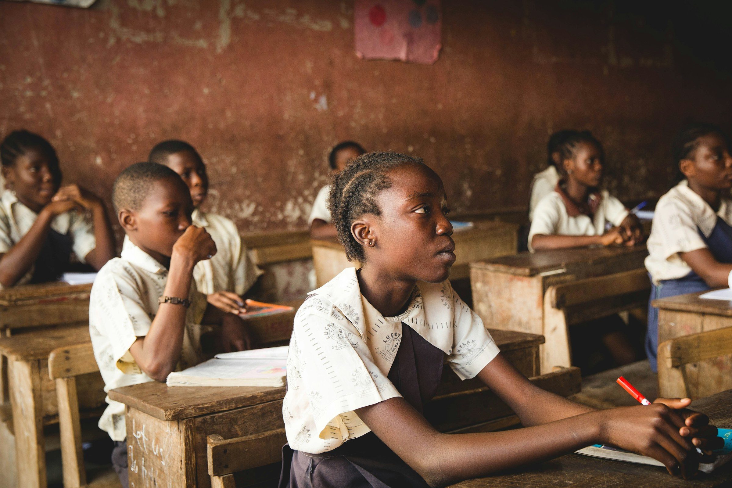 Pupils seated at wooden desks in a classroom