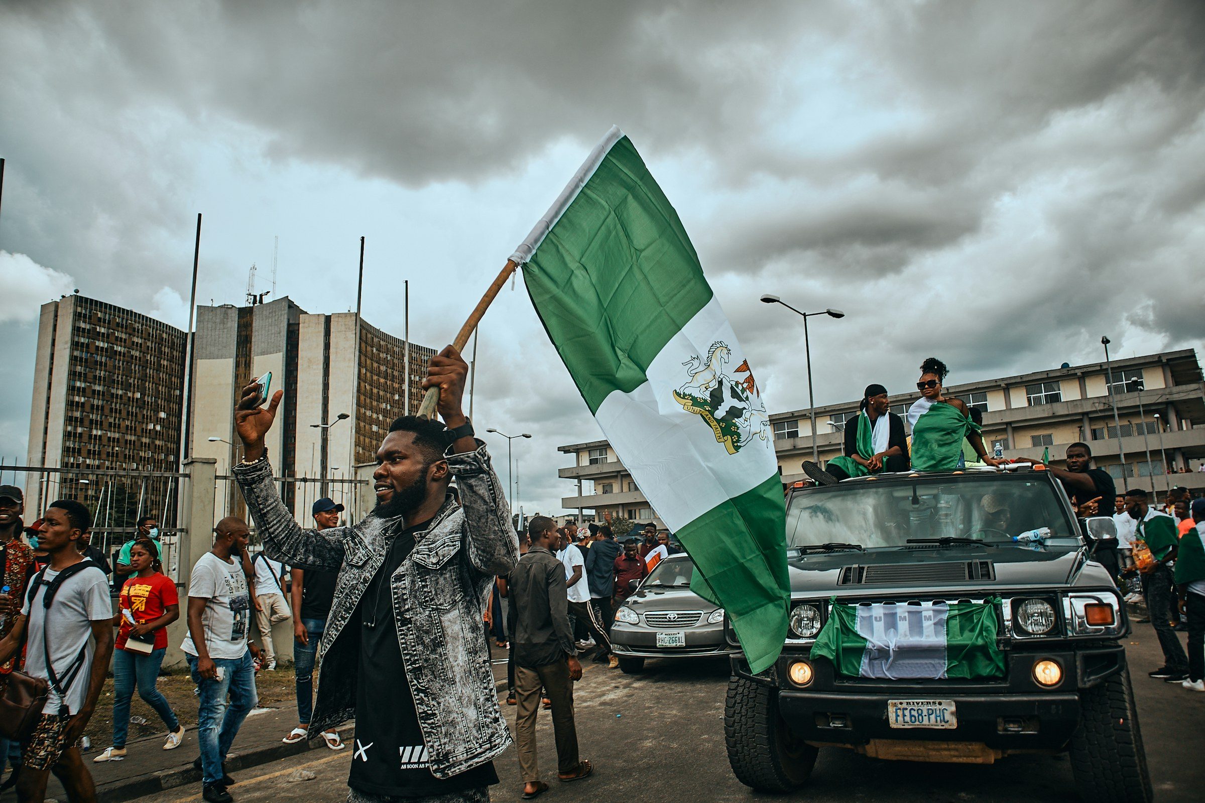 A campaign convoy with a supporter waving the Nigerian flag