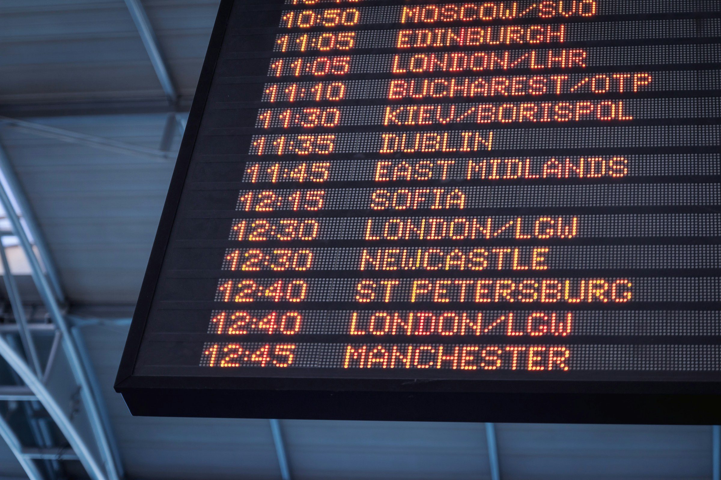 An airport departures board listing international flights