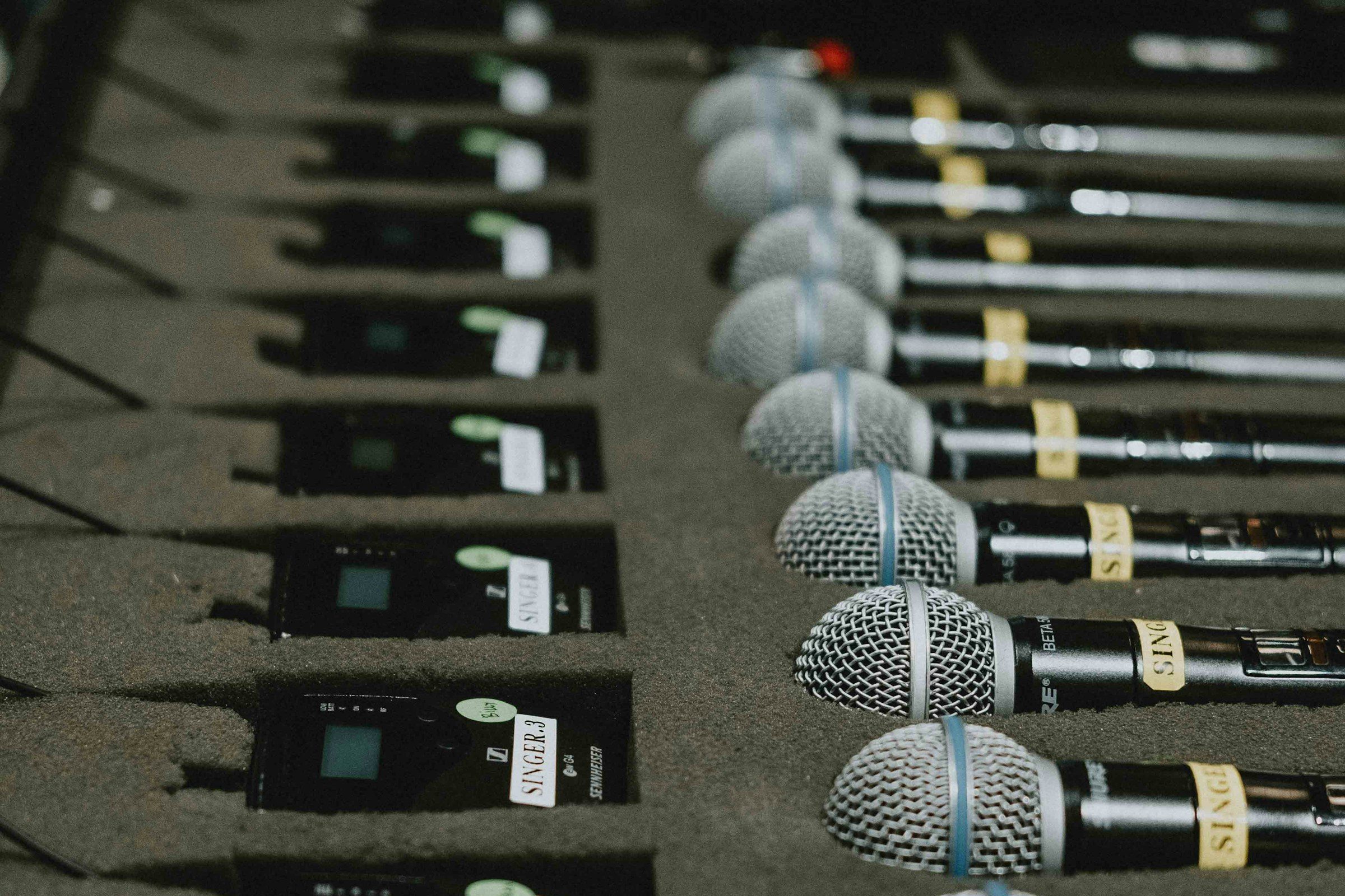 Microphones lined up on a table before an event