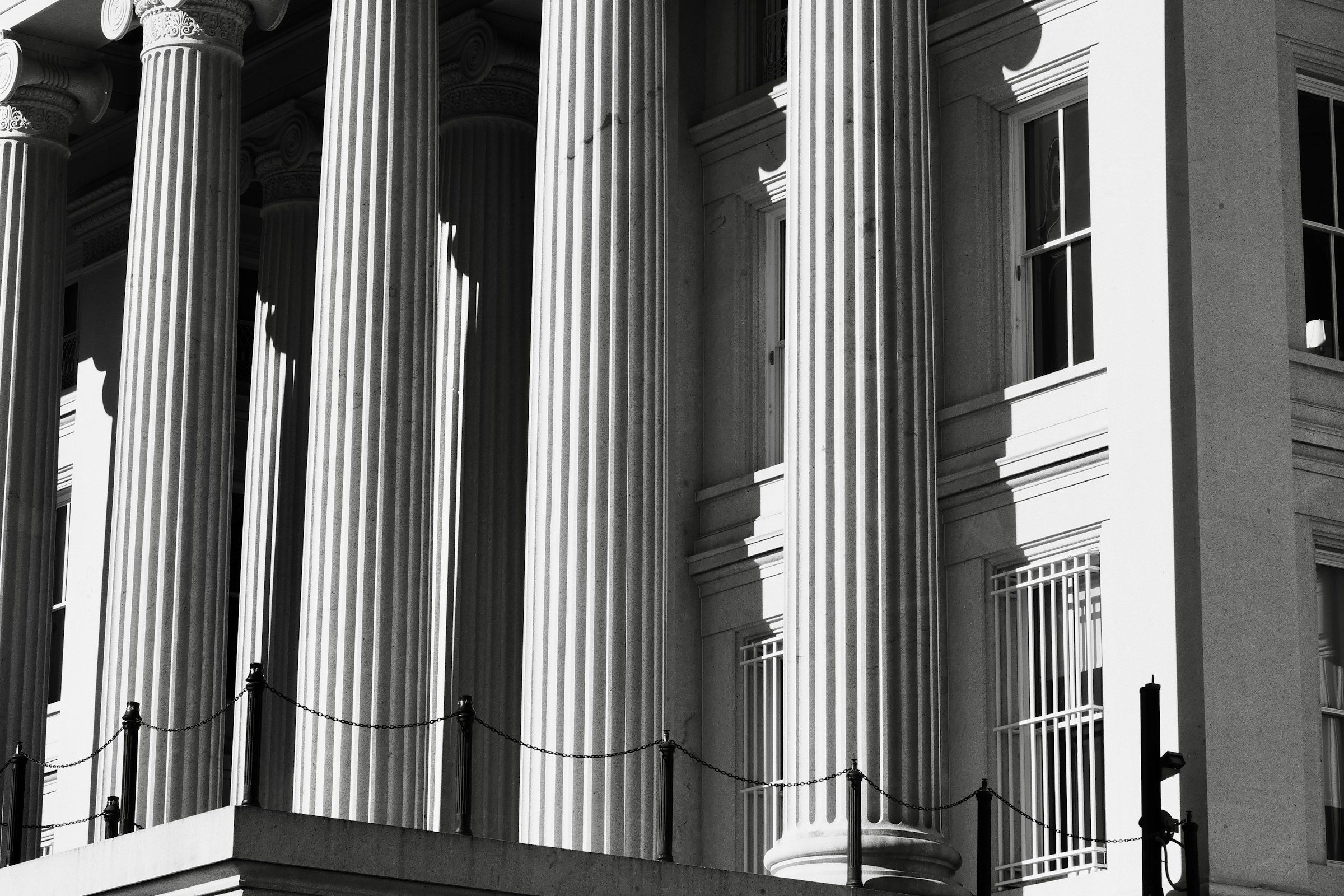 The columned facade of a public building, in black and white