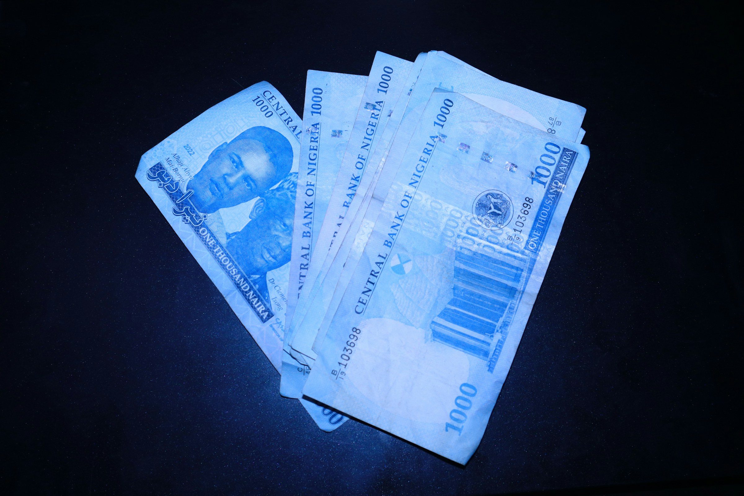 One-thousand-naira notes fanned out on a dark surface